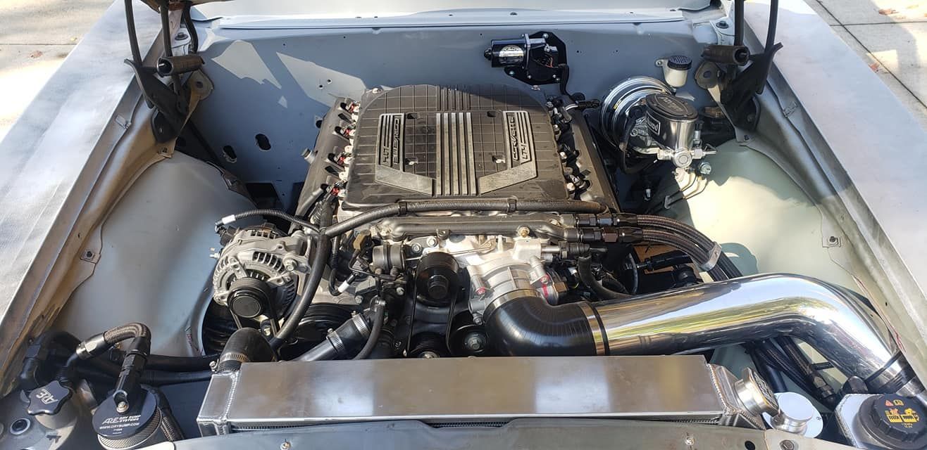 A close up of a car engine with the hood open.
