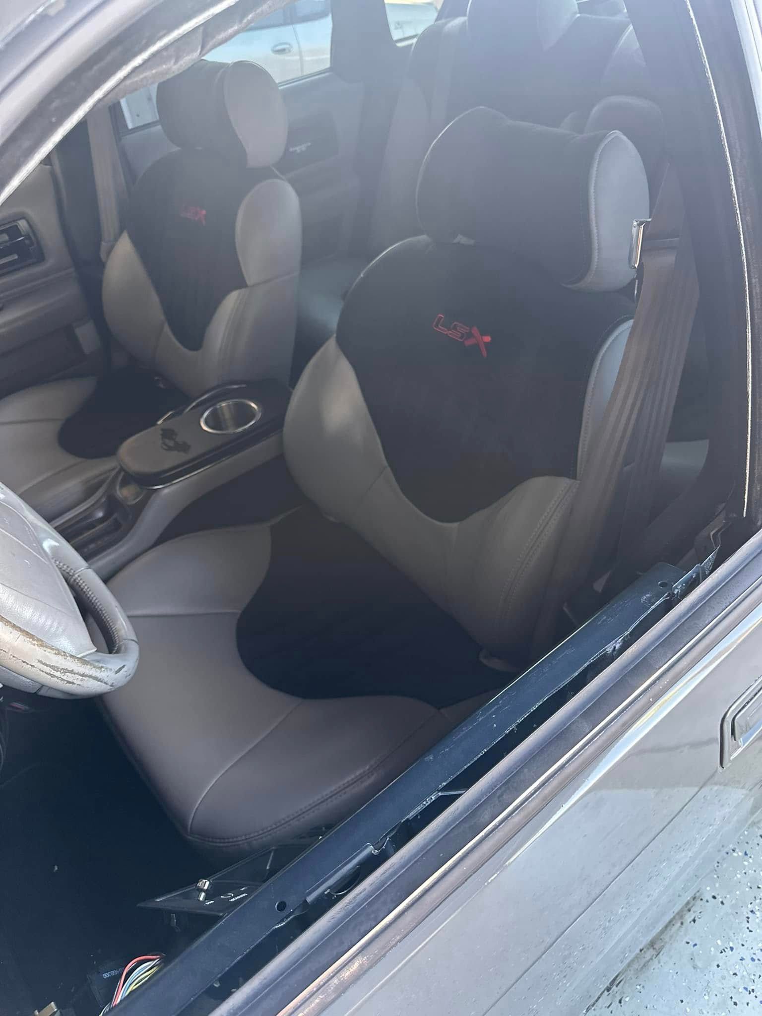 The inside of a car with a broken window and a steering wheel.