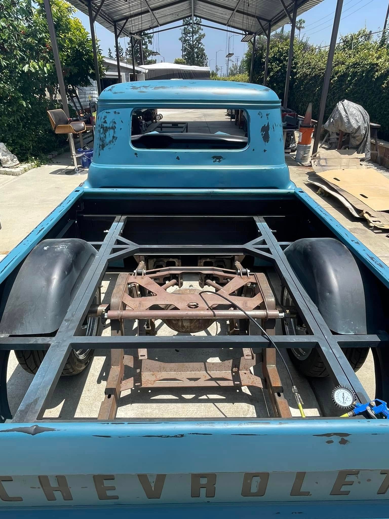 The back of a blue chevrolet truck is shown.