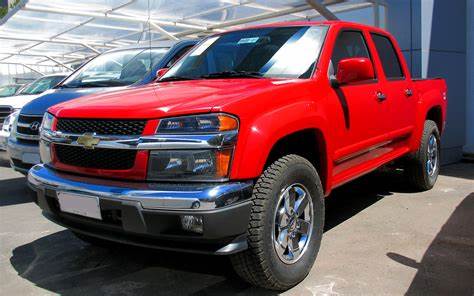 A red pickup truck is parked in a parking lot