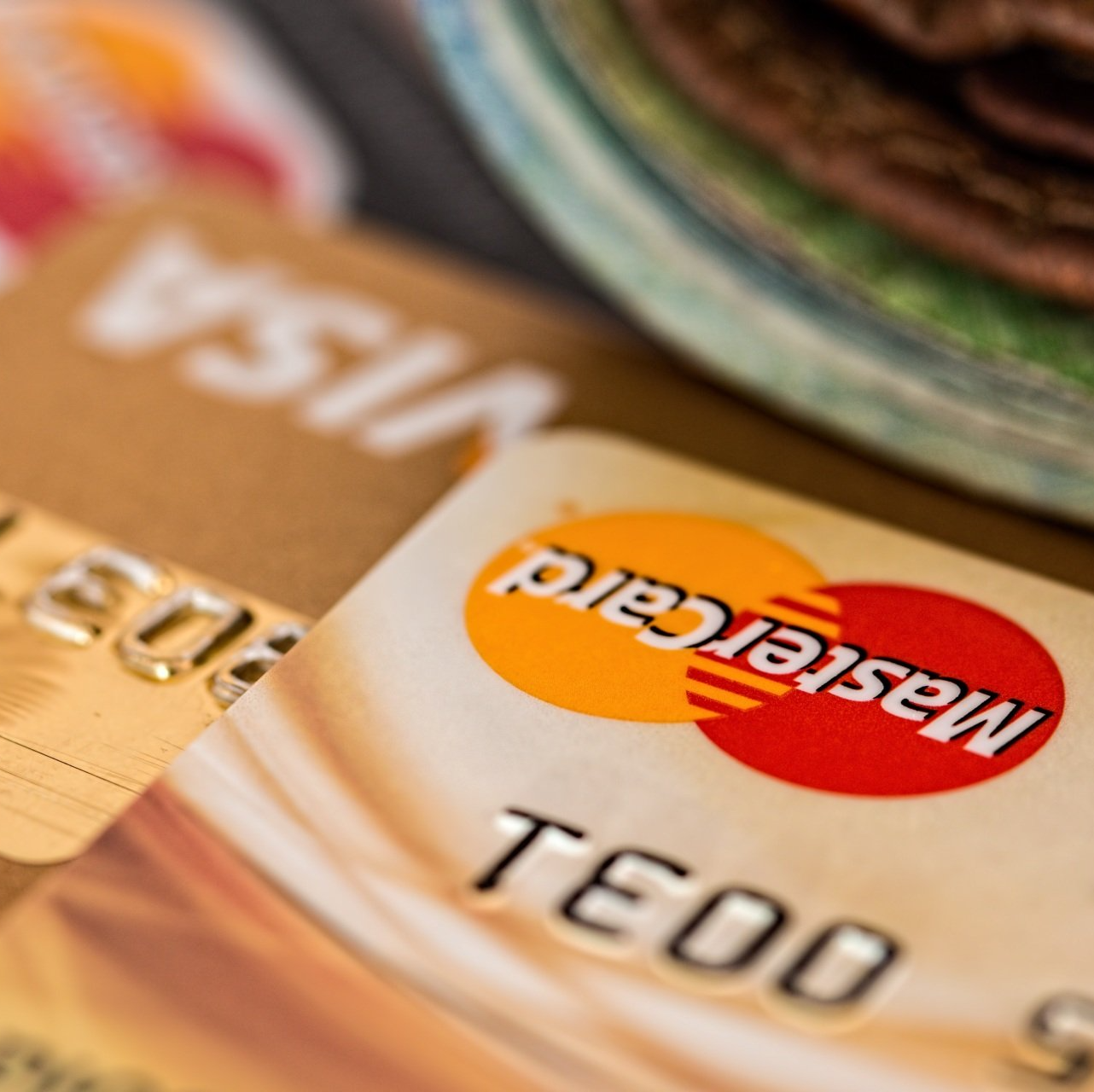 A close up of a mastercard card next to a visa card