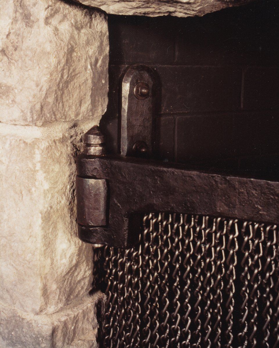 detail of custom made fire screen with fireplace tools