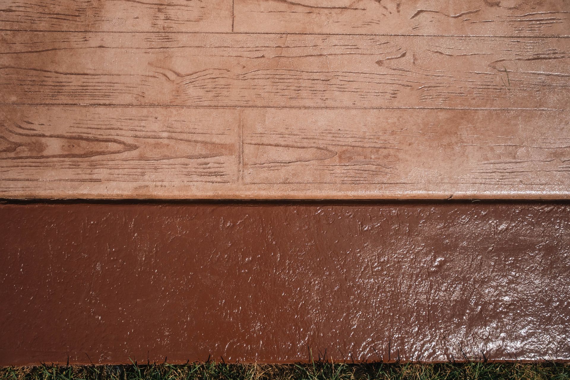Brown stamped concrete with wood grain texture above and smooth brown finish below.