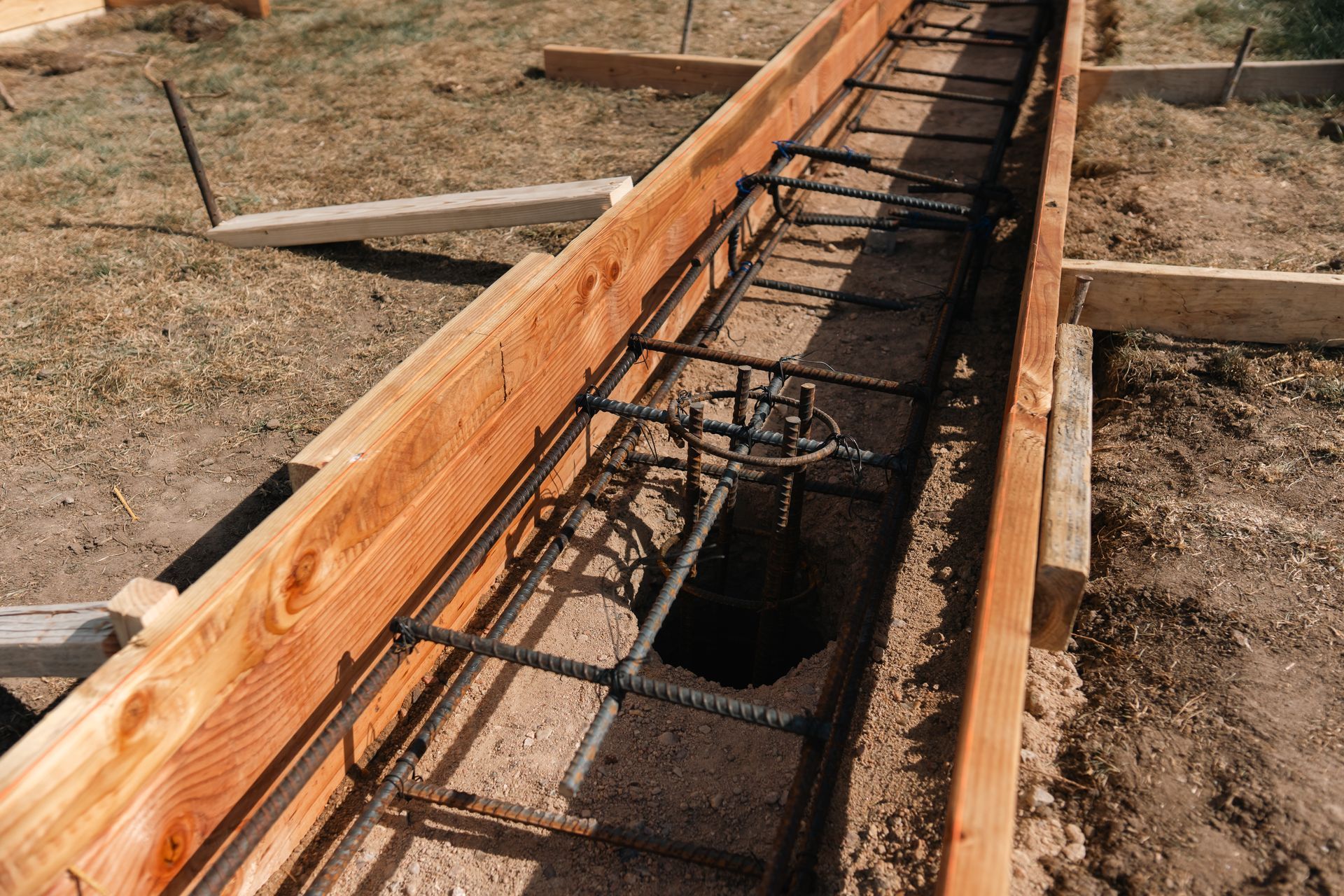 Wooden forms with rebar in a trench, ready for concrete foundation.