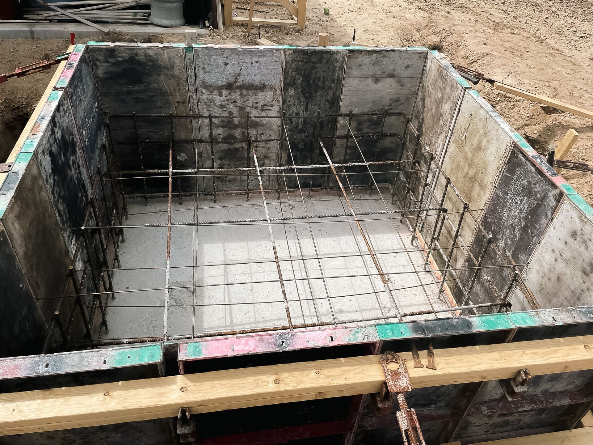 A large concrete container is being built on a construction site.