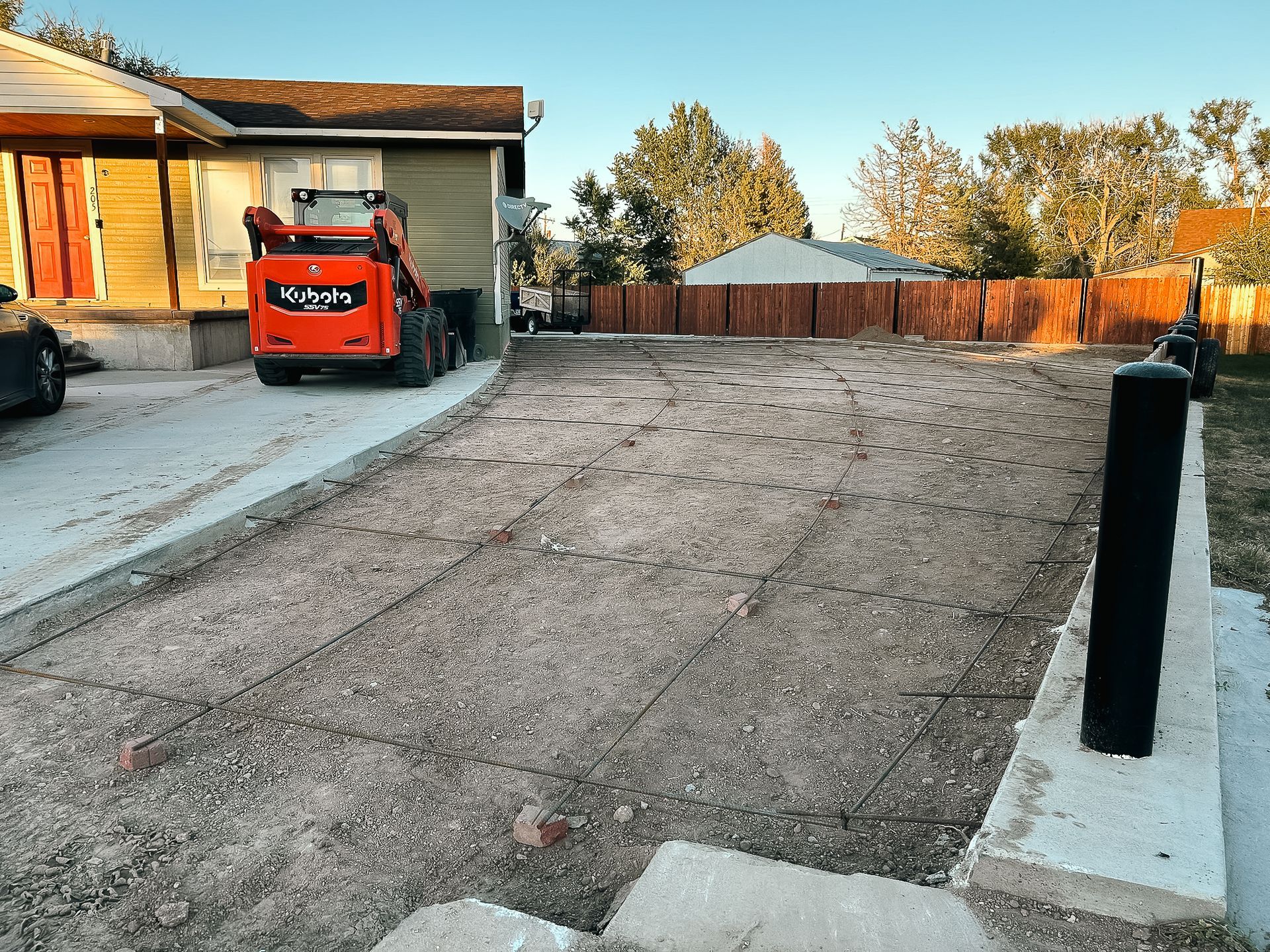 A bulldozer is parked in a driveway next to a house.