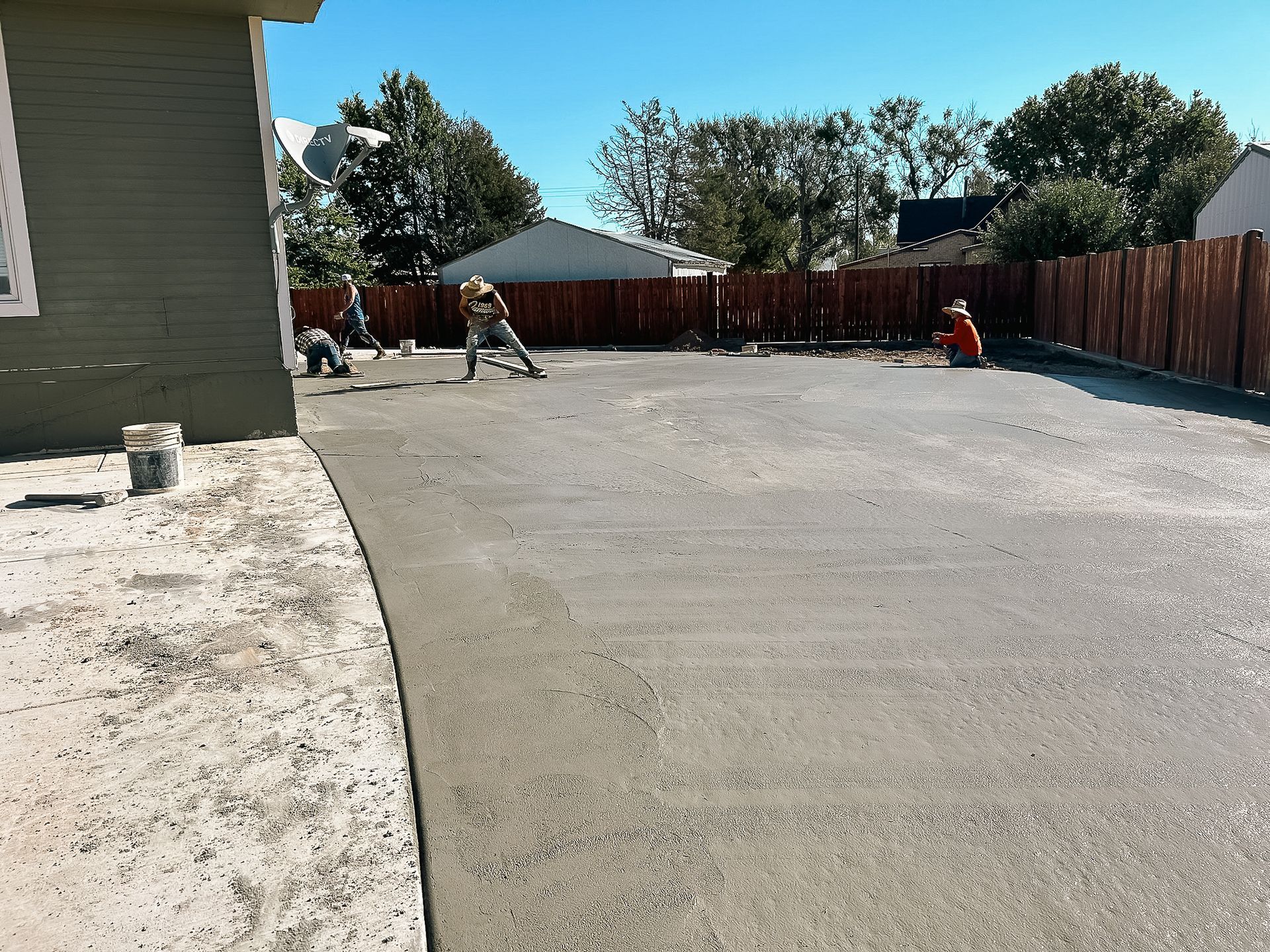 A concrete driveway is being built in front of a house