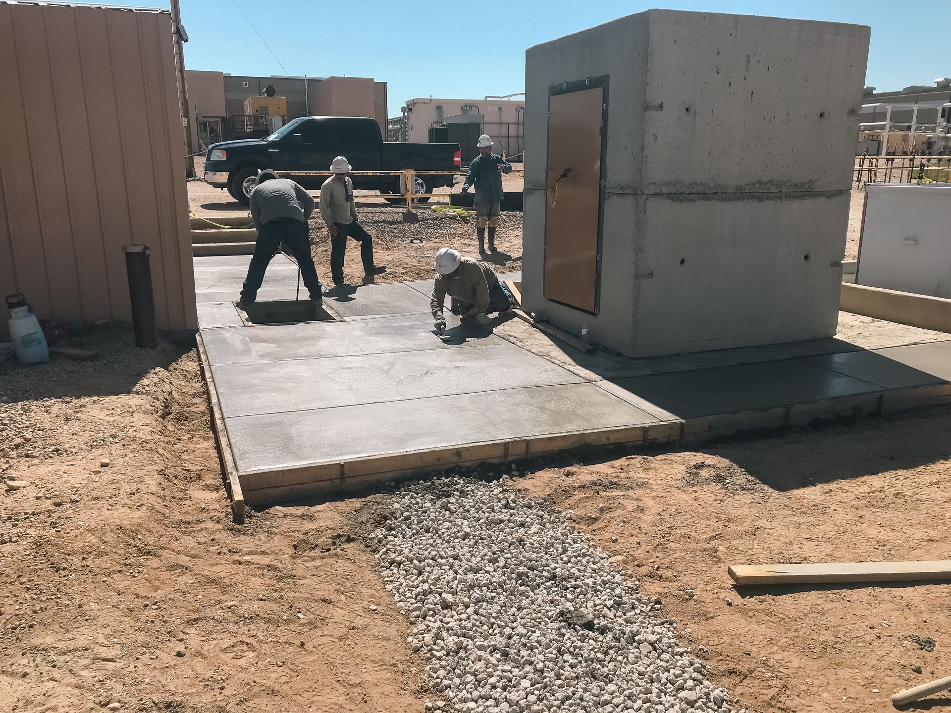 A group of construction workers are working on a concrete slab.