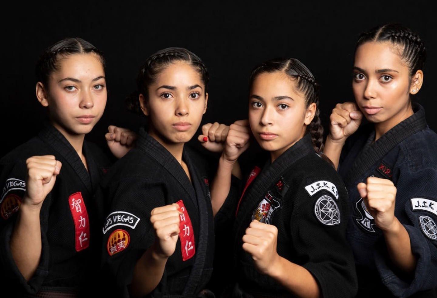 a group of young girls in karate uniforms are posing for a picture .