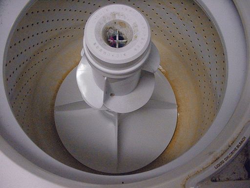The inside of a dirty washing machine with holes in it