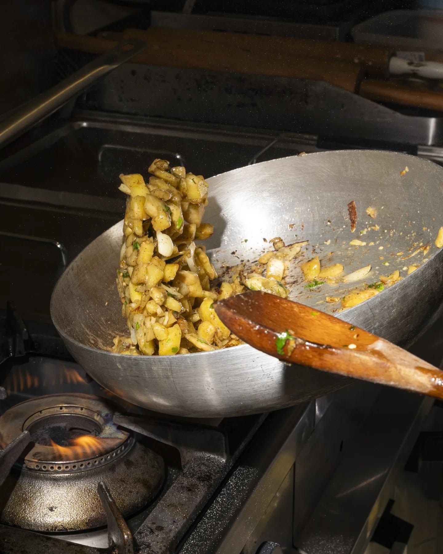 Una persona sta mescolando il cibo in una padella con un cucchiaio di legno