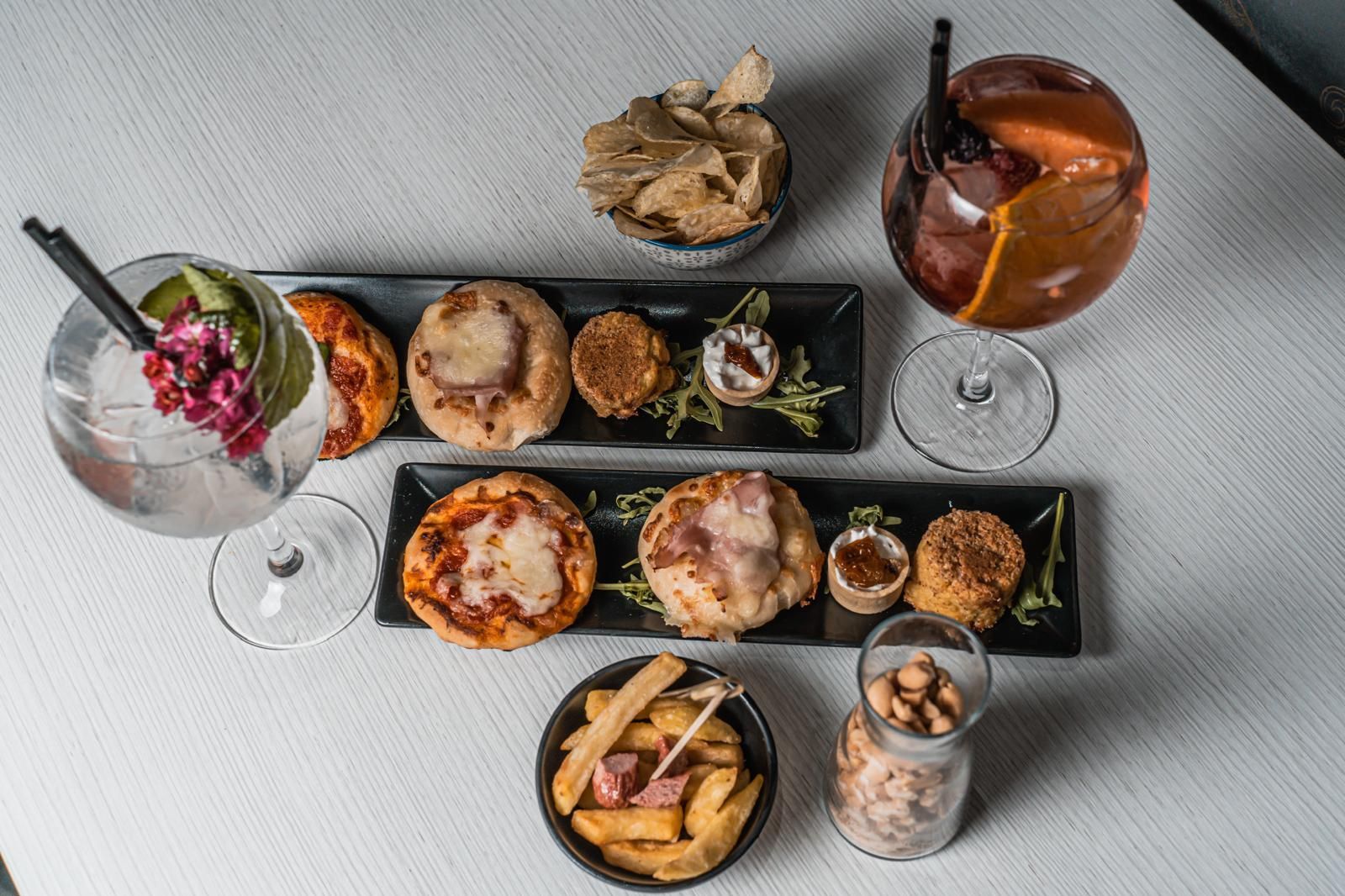 Un tavolo sormontato da piatti di cibo e bevande.