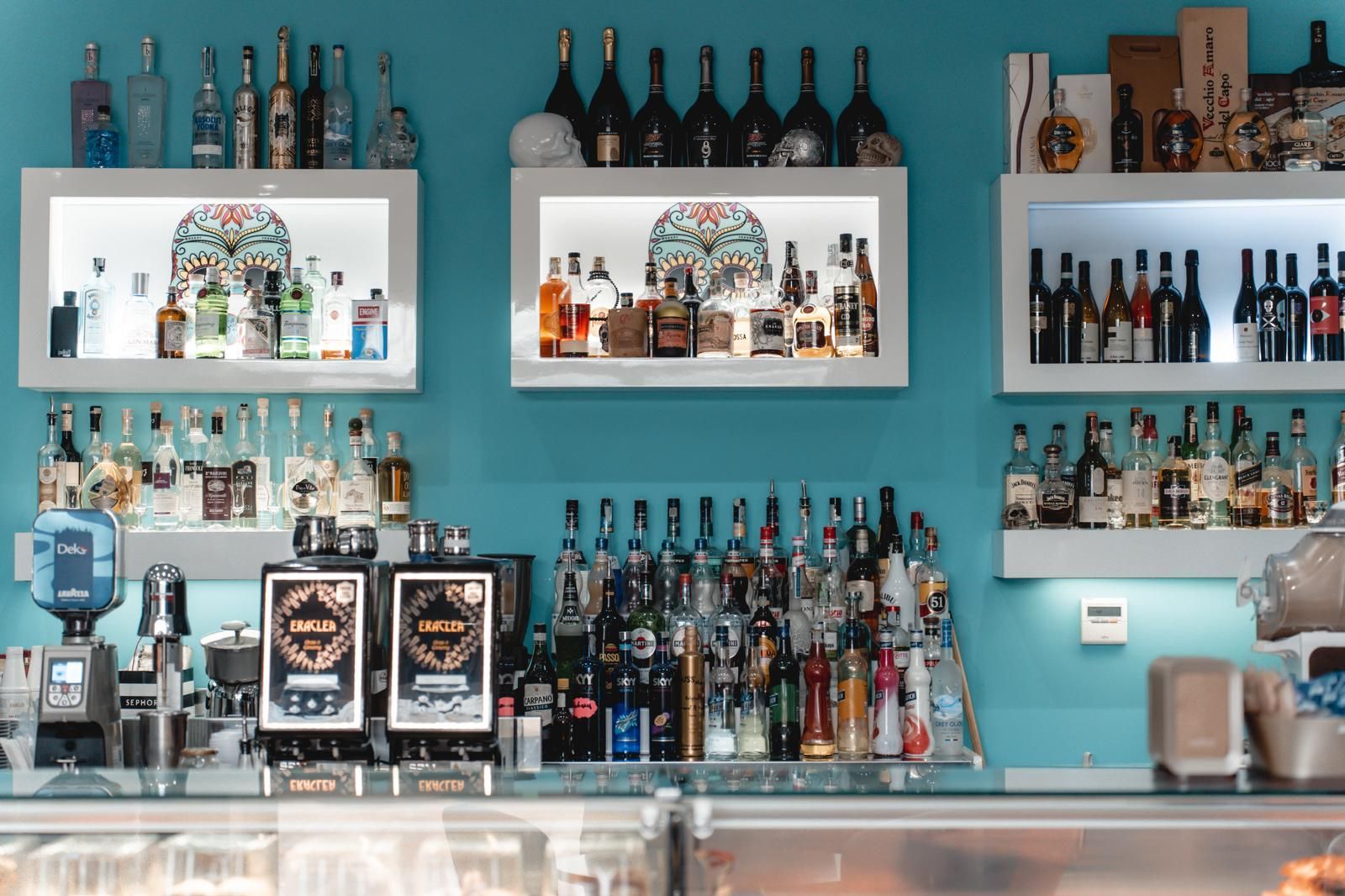 Un bar con tante bottiglie sugli scaffali