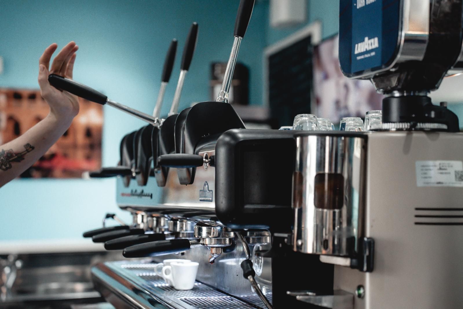 Una persona versa il caffè in una tazza in una caffetteria.