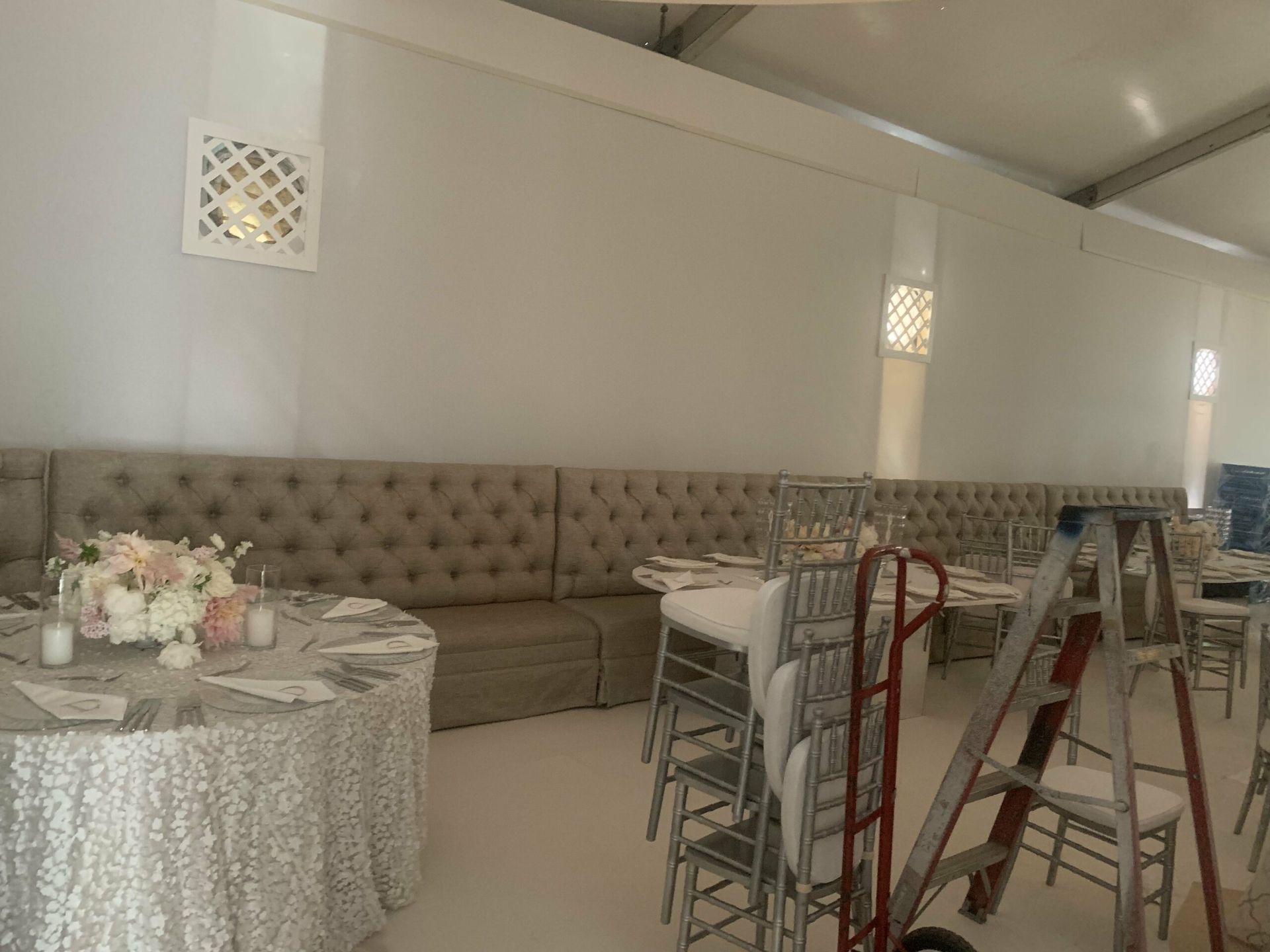 A large room with tables and chairs set up for a wedding reception.