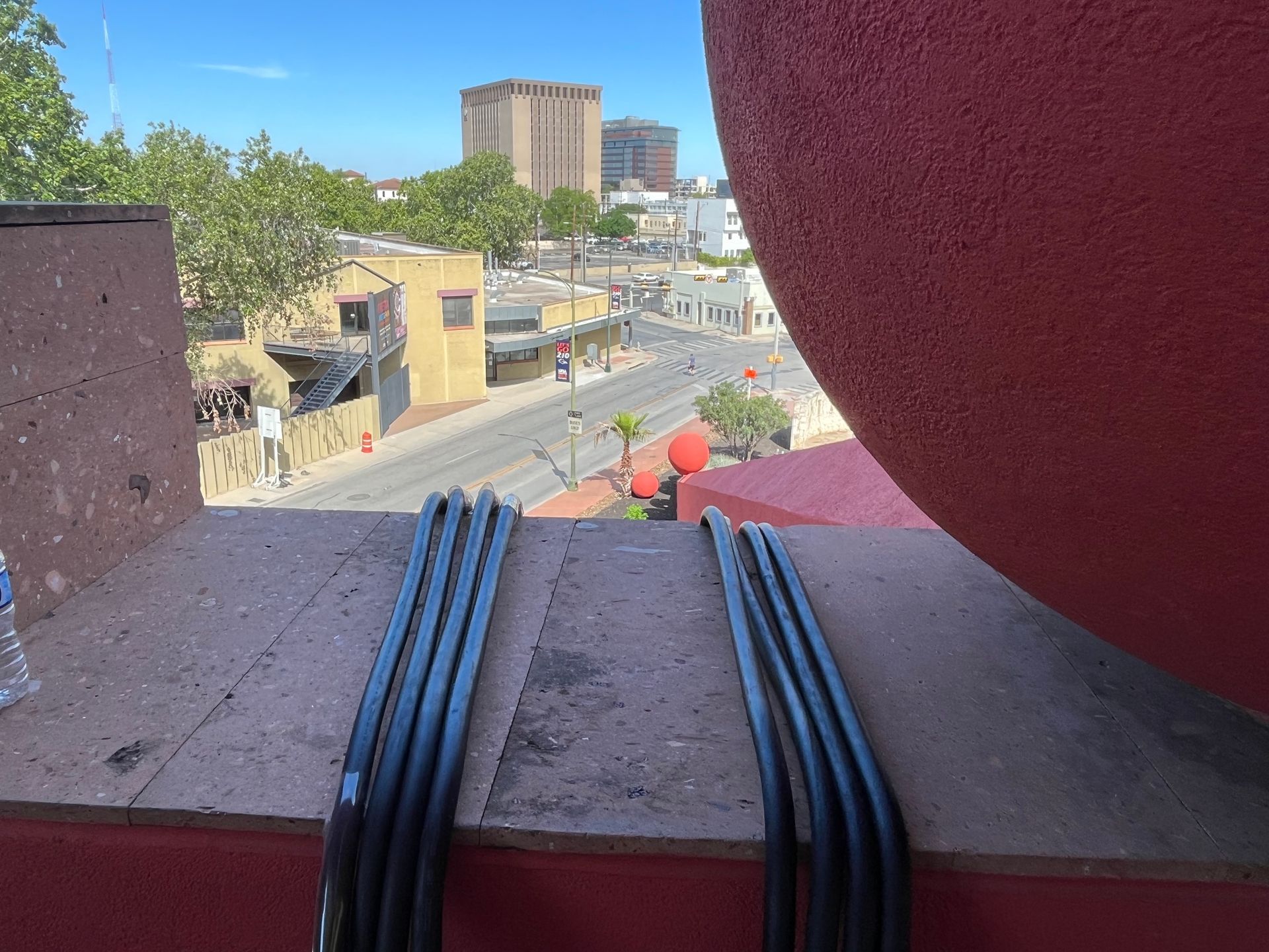 A bottle of water sits on a balcony overlooking a city