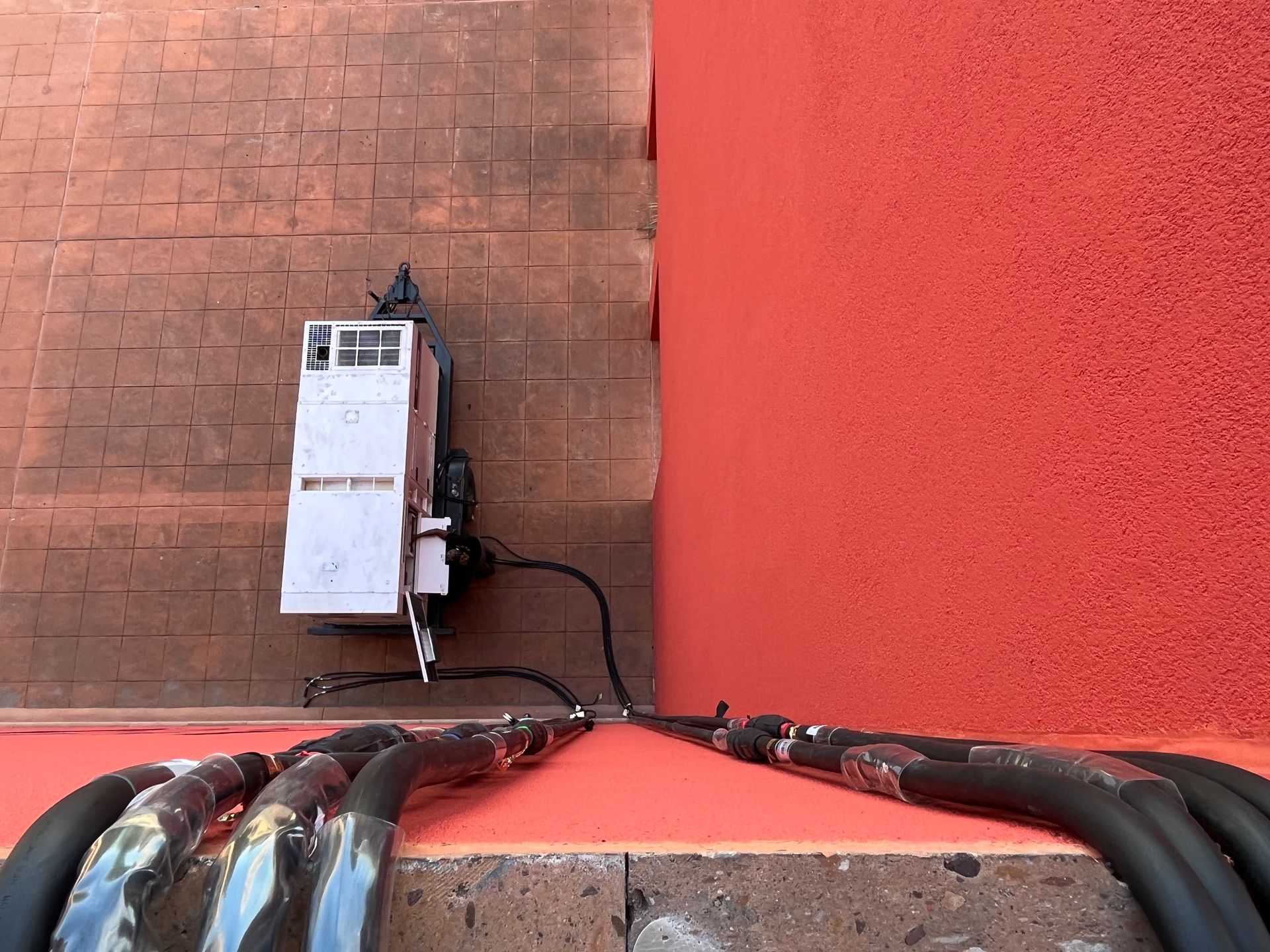 A bunch of wires are connected to a red wall