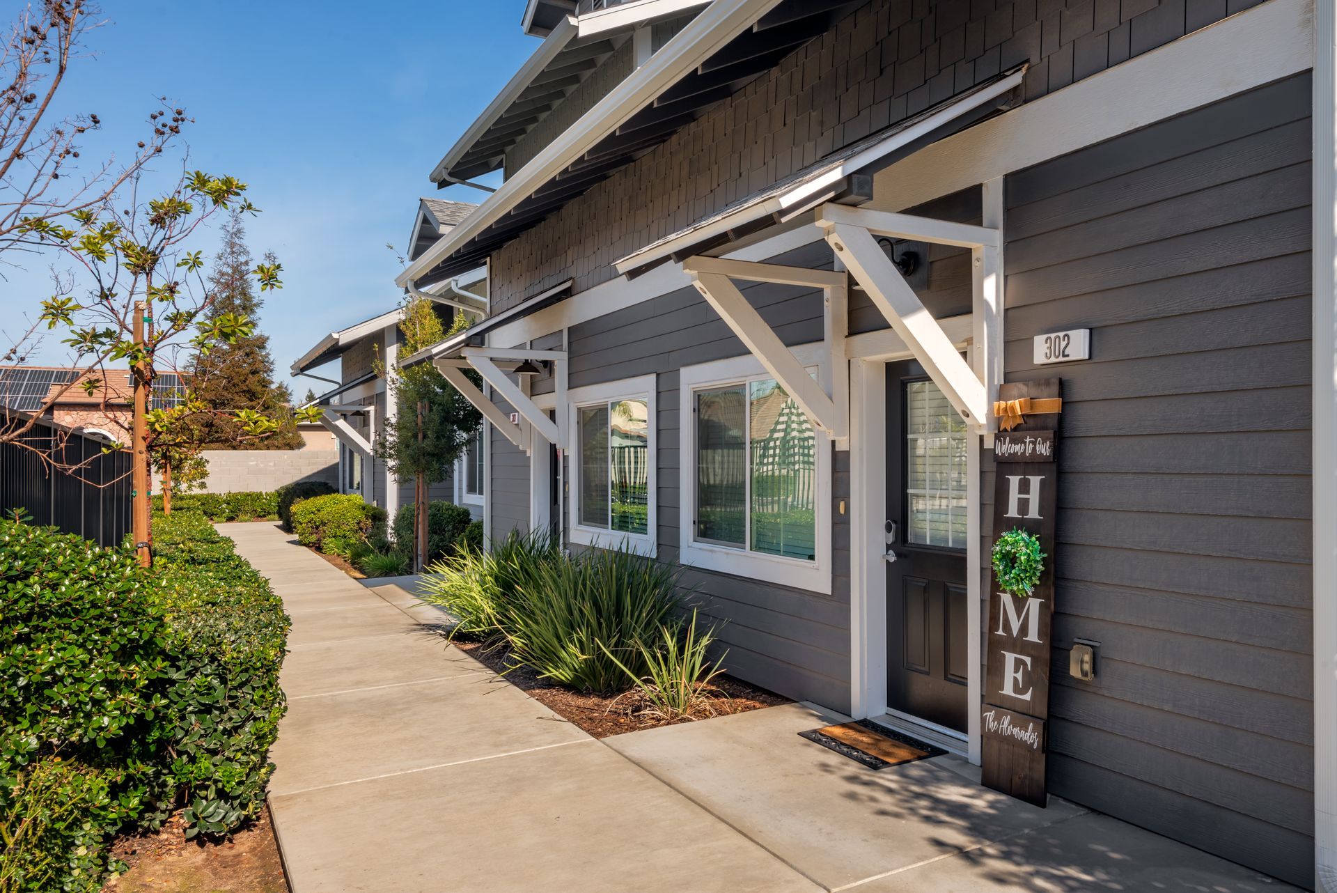 Gray building with white awnings, a walkway, and a