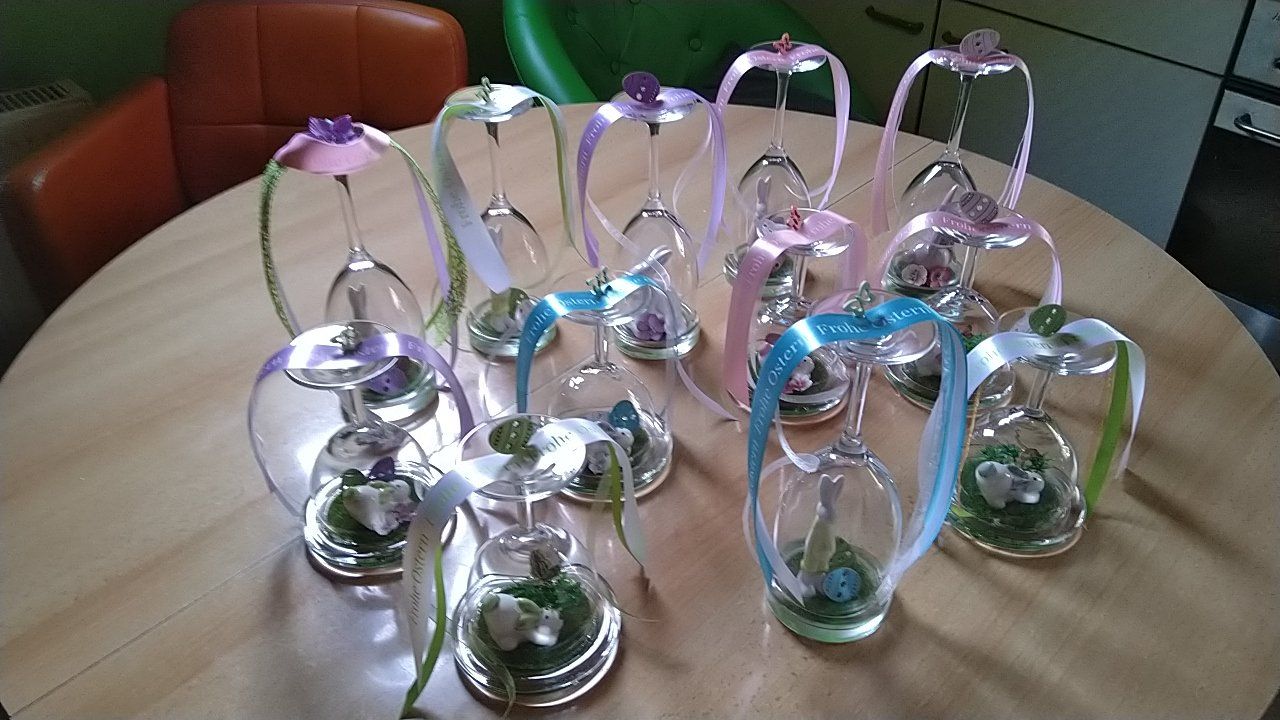 Ein Strauß Weingläser mit Blumen darin auf einem Tisch