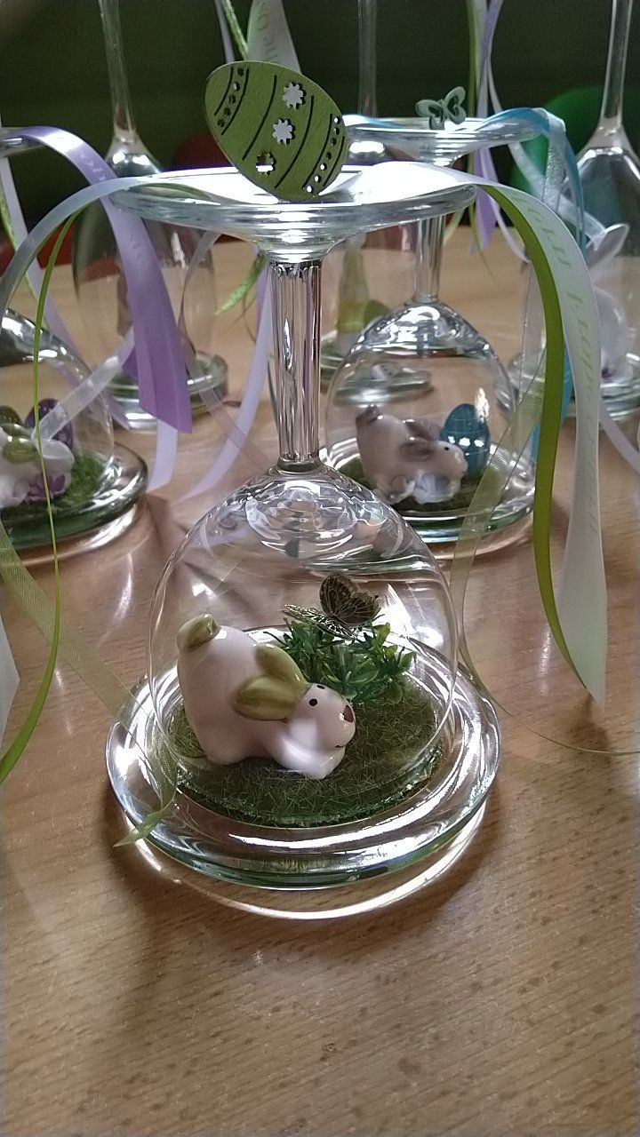 Ein Weinglas mit einem Häschen darauf auf einem Tisch.