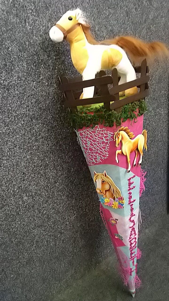 Ein ausgestopftes Pferd sitzt auf einem rosa Kegel.