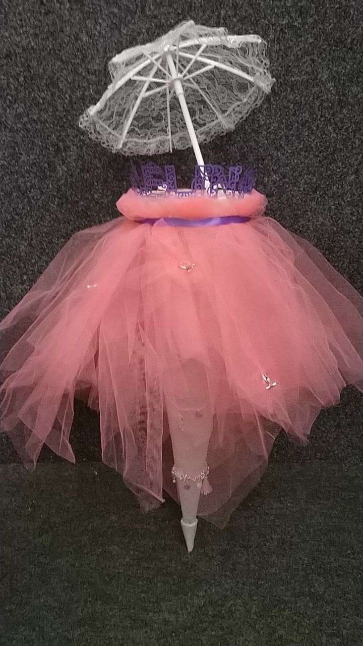 Ein rosa Tutu mit einem weißen Regenschirm darüber.