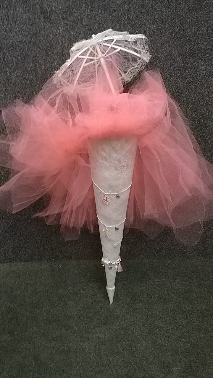 Ein rosa Tüllkegel mit einem daran befestigten weißen Schirm.