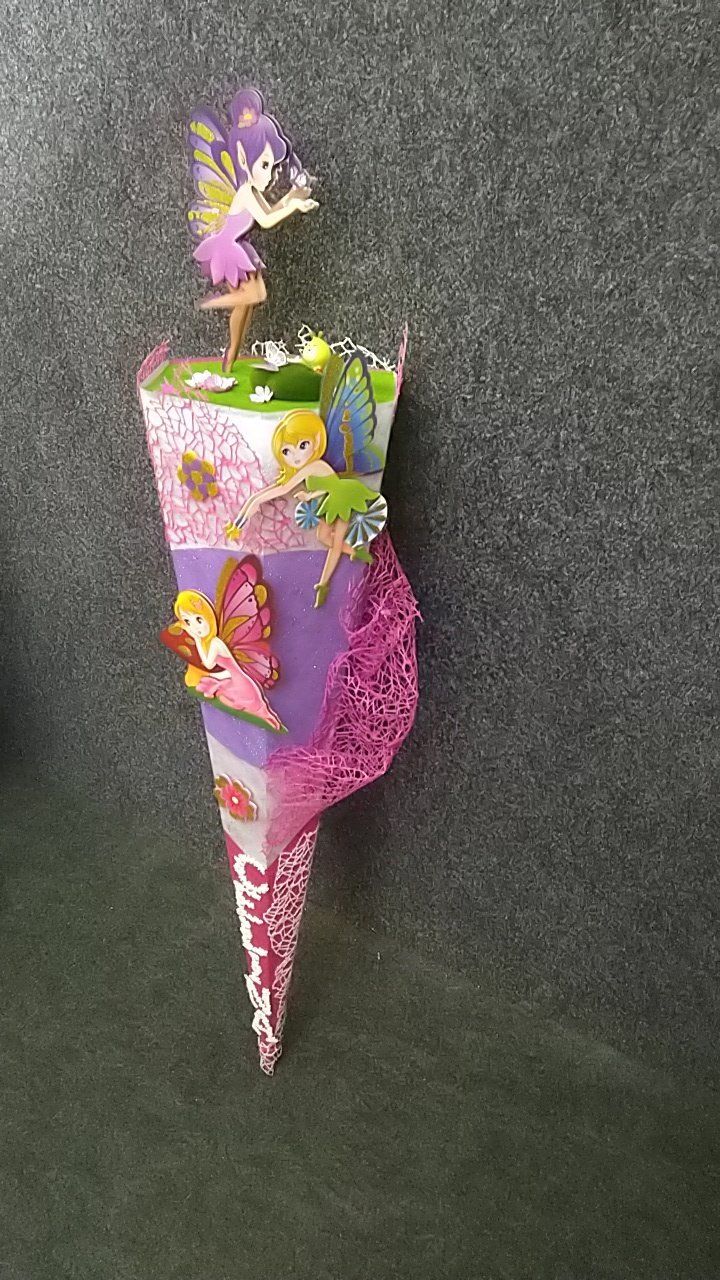 An einer Wand hängt ein Kegel mit Feenfiguren darauf.