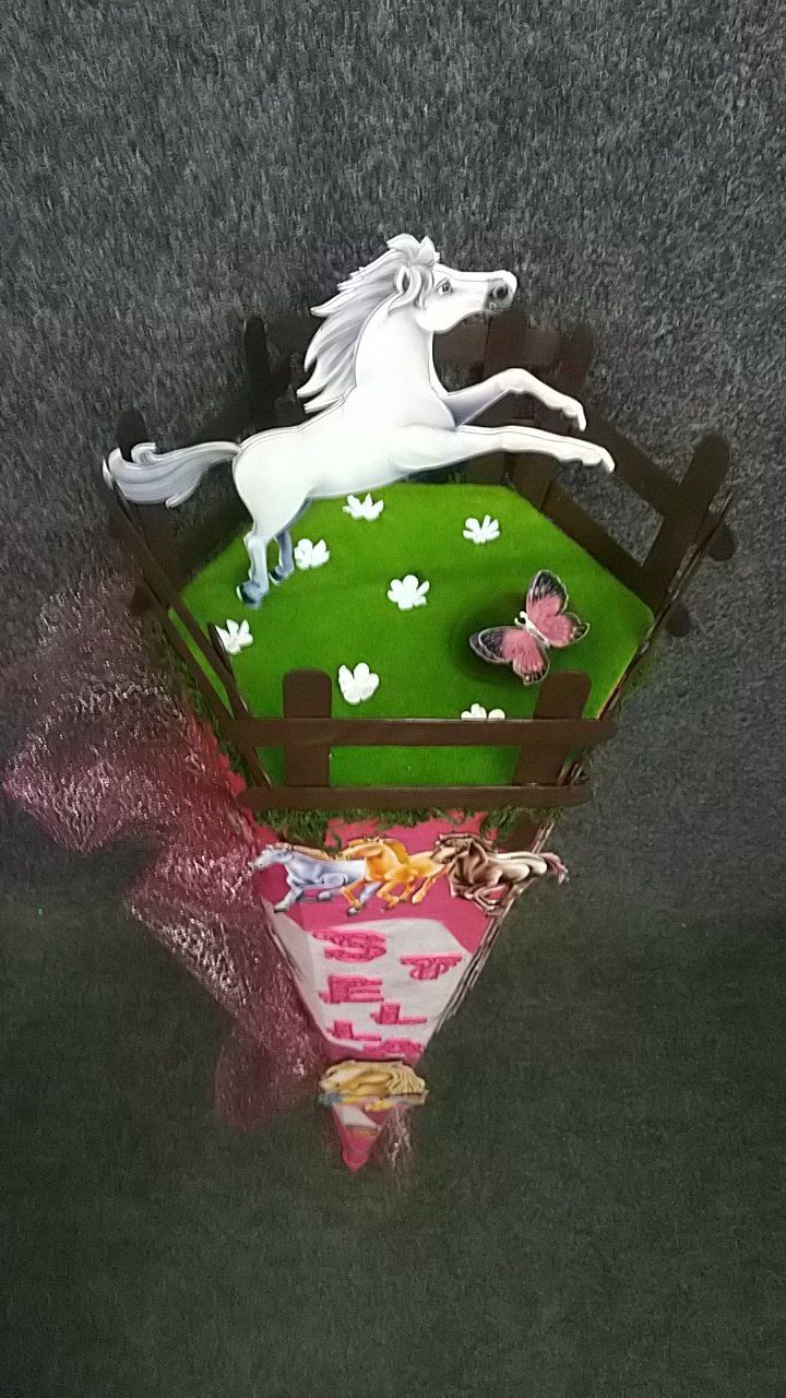 Ein weißes Pferd springt über einen Holzzaun.