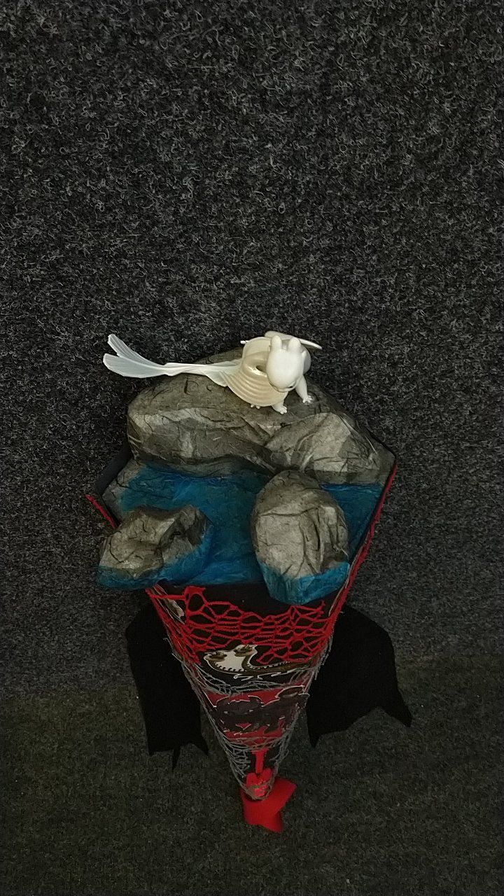 Ein weißer Vogel sitzt auf einem Felsen neben einem Fluss.