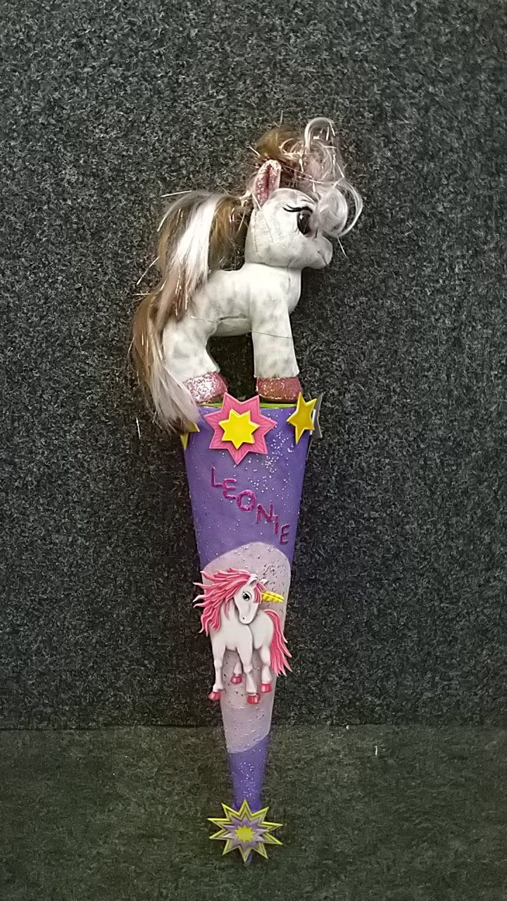 Ein ausgestopftes Einhorn sitzt auf einem lila Kegel.
