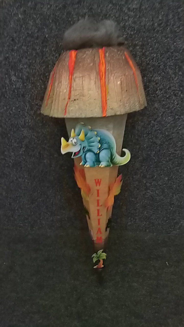 Eine Eistüte mit einem Dinosaurier oben drauf