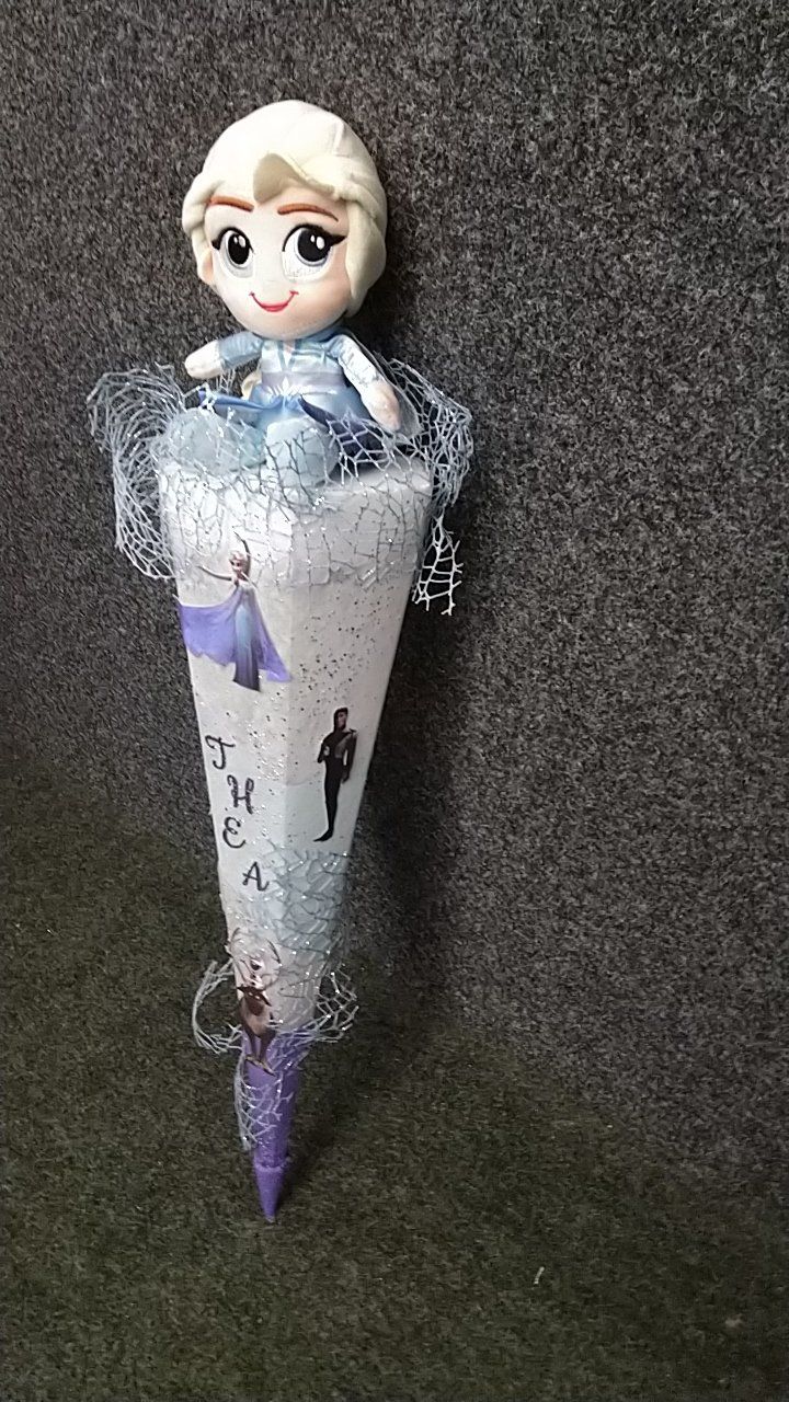 Eine Puppe sitzt auf einer Eistüte.