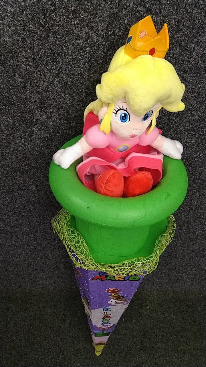 Eine Prinzessin-Peach-Puppe sitzt in einer grünen Eistüte.
