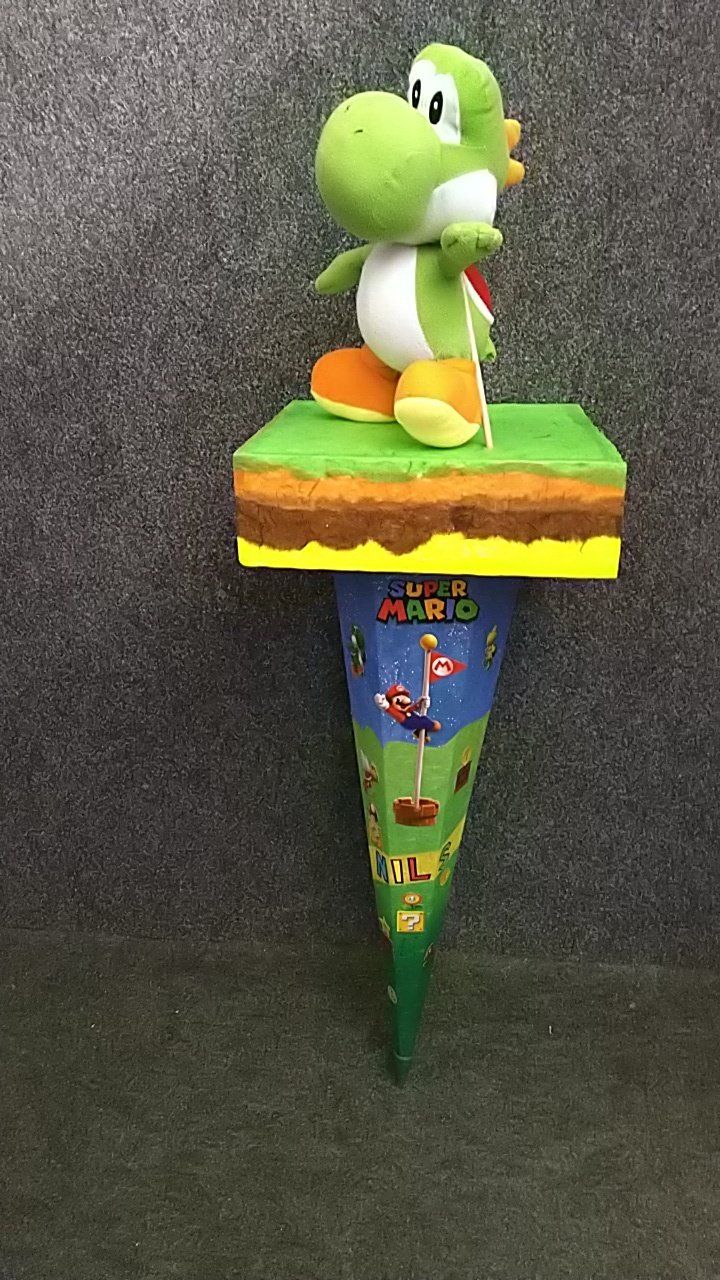 Ein ausgestopfter Yoshi sitzt auf einer Papiertüte.