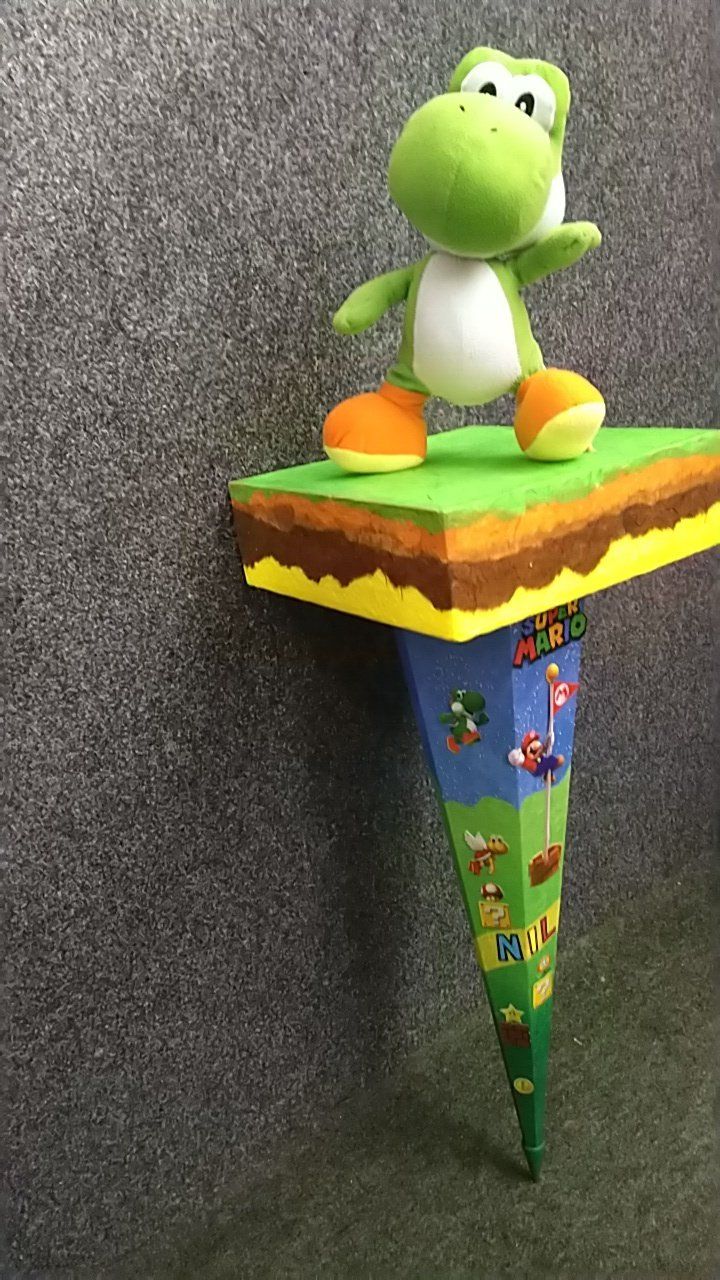 Ein ausgestopfter Yoshi steht oben auf einem Regal.