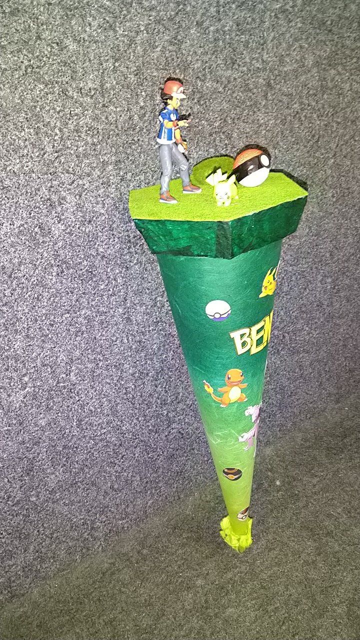 Ein grüner Kegel, auf dem die Figur eines Mannes steht.