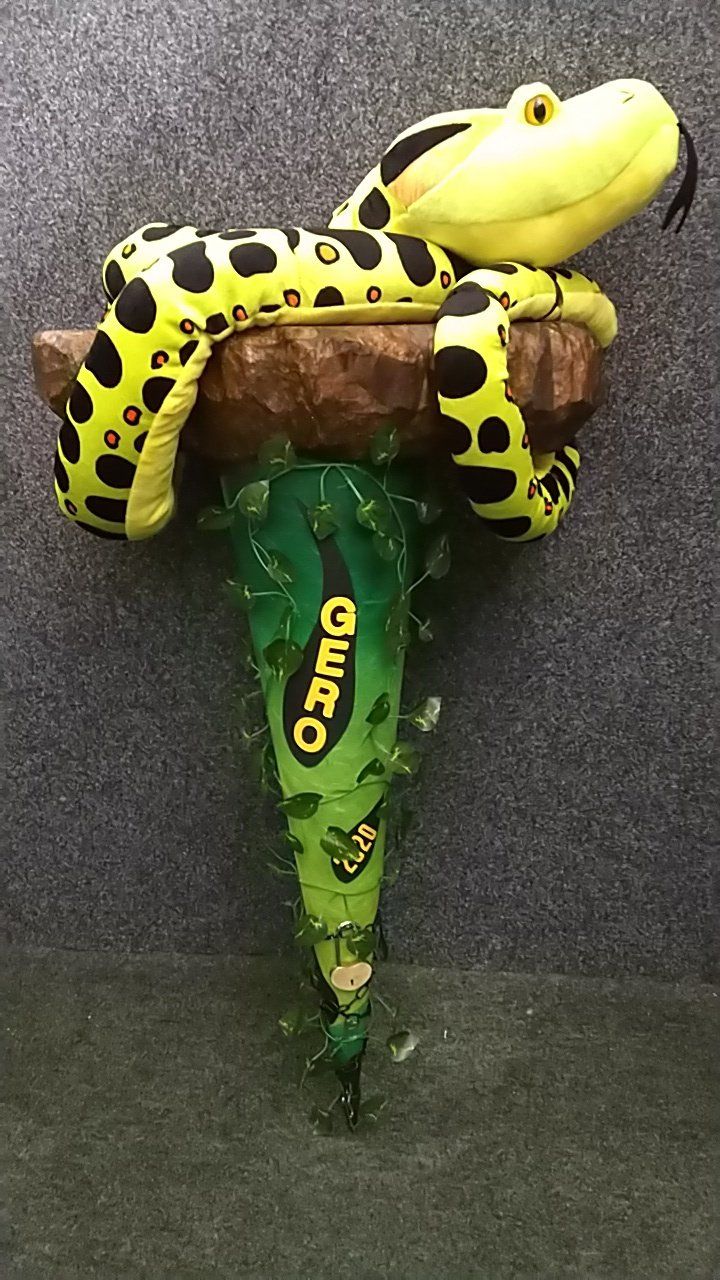 Eine gelb-schwarze Schlange liegt auf einem Ast.