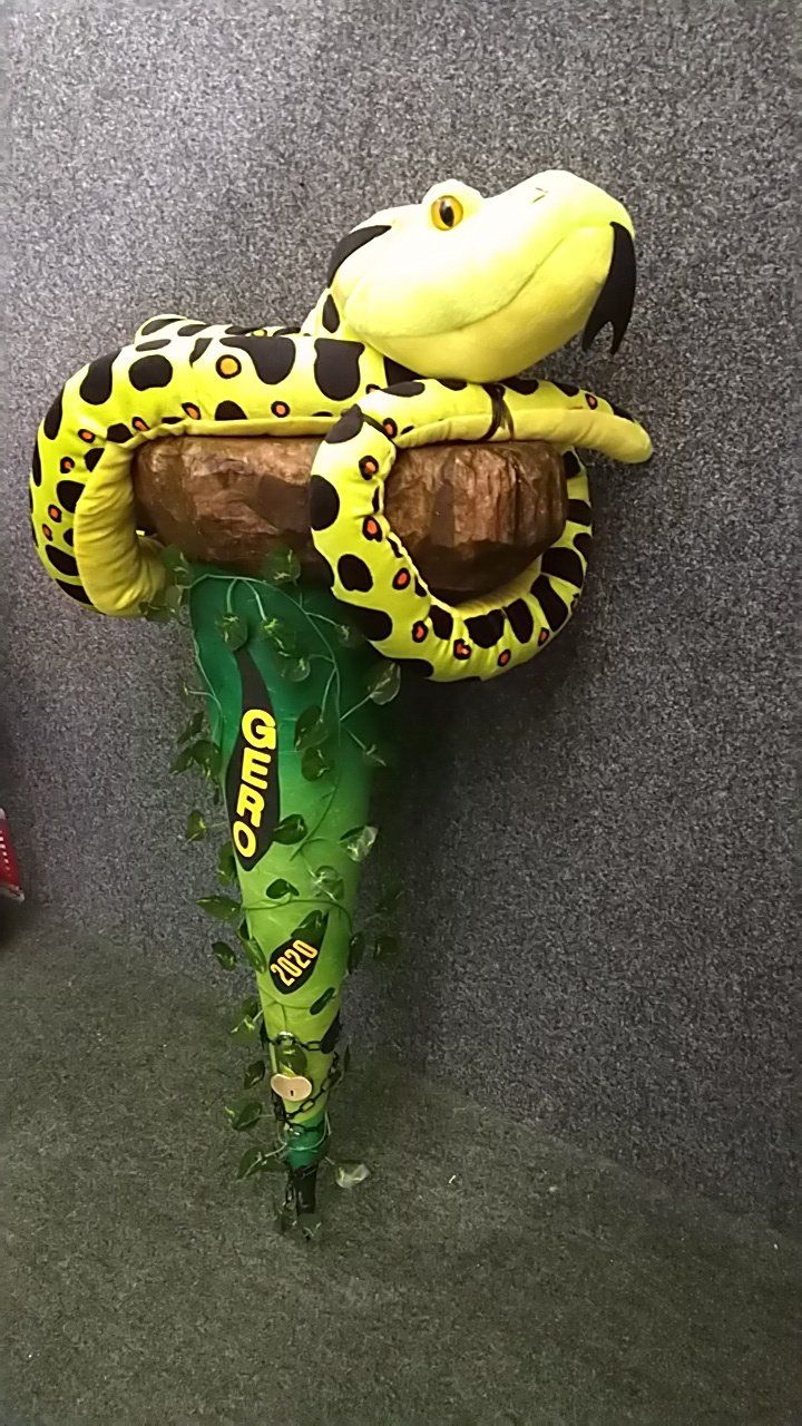 Ein Ballon in Form einer Schlange hängt von einem Ast.