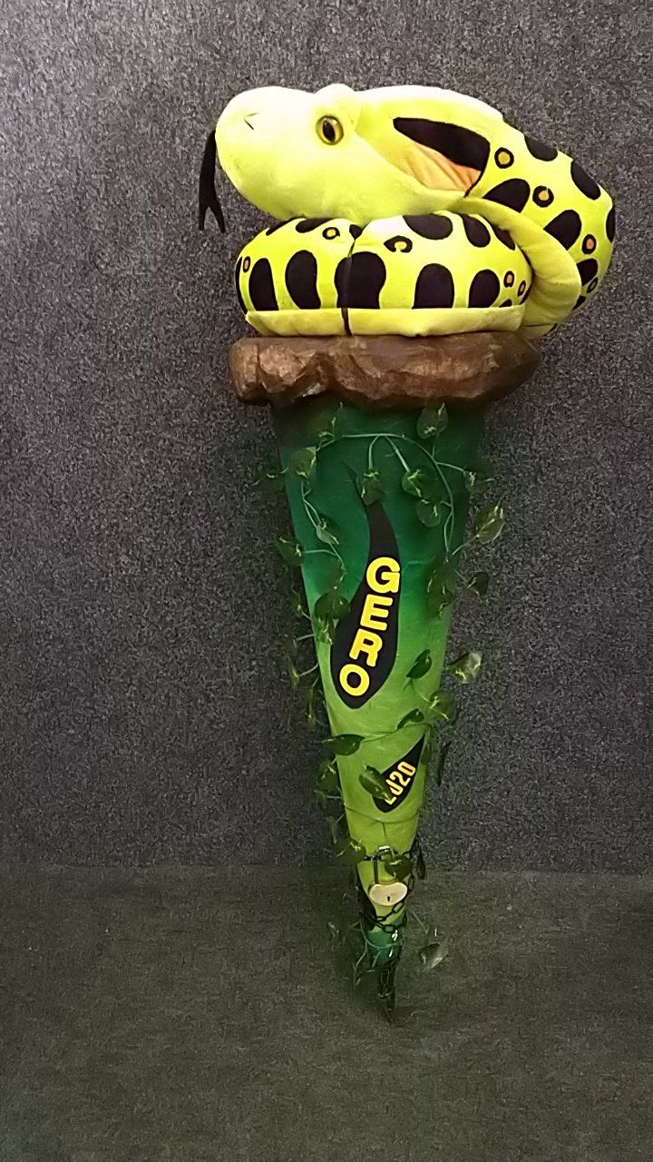 Eine ausgestopfte Schlange sitzt auf einer Eistüte.