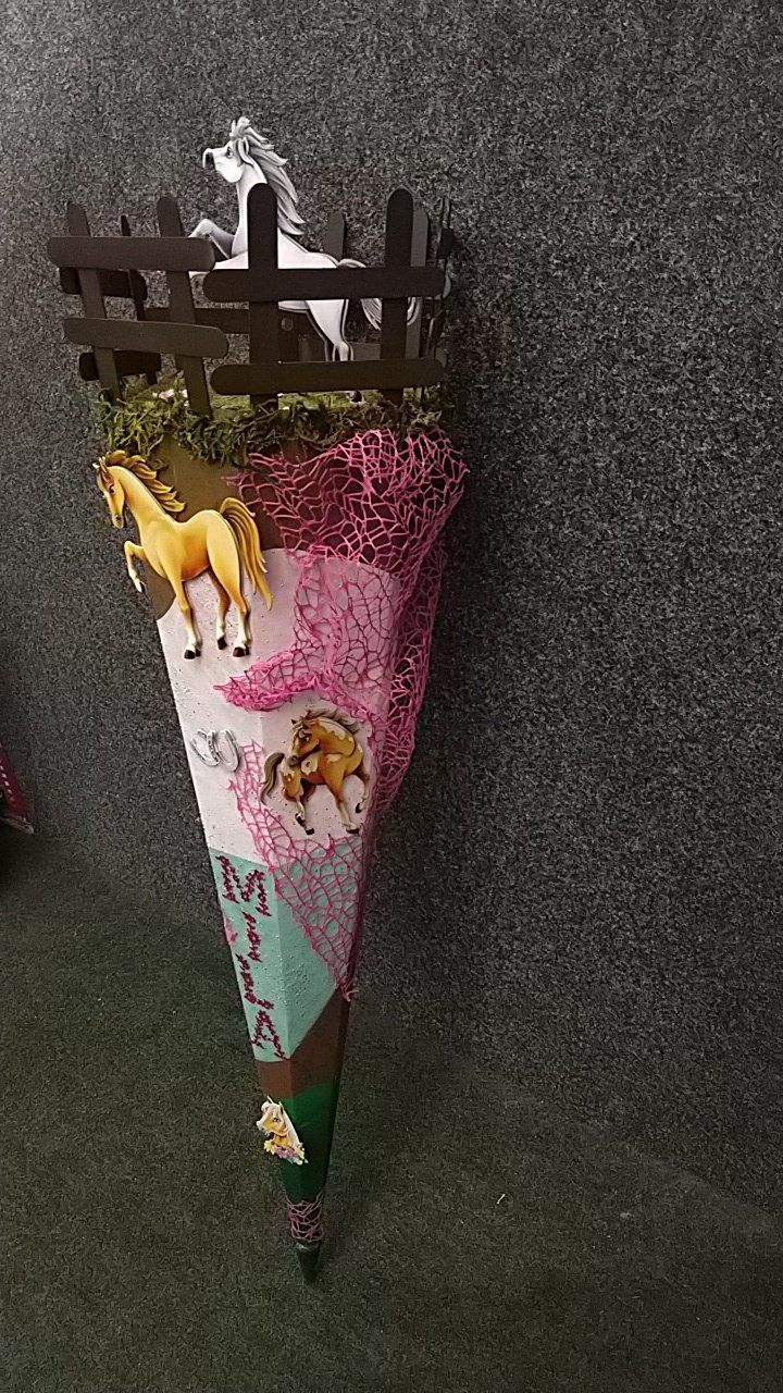 Ein Kegel mit zwei Pferden und einem Zaun darauf.