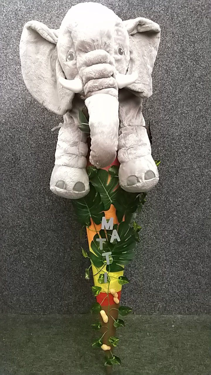 Ein ausgestopfter Elefant sitzt auf der Spitze eines Astes.