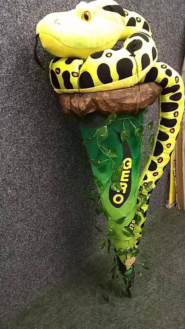 Eine ausgestopfte Schlange sitzt auf einer Eistüte.