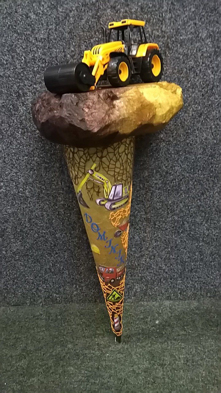 Ein Spielzeugtraktor sitzt auf einer Eistüte.