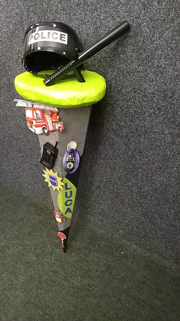 Auf einem grünen Ballon sitzt ein Polizeihelm.