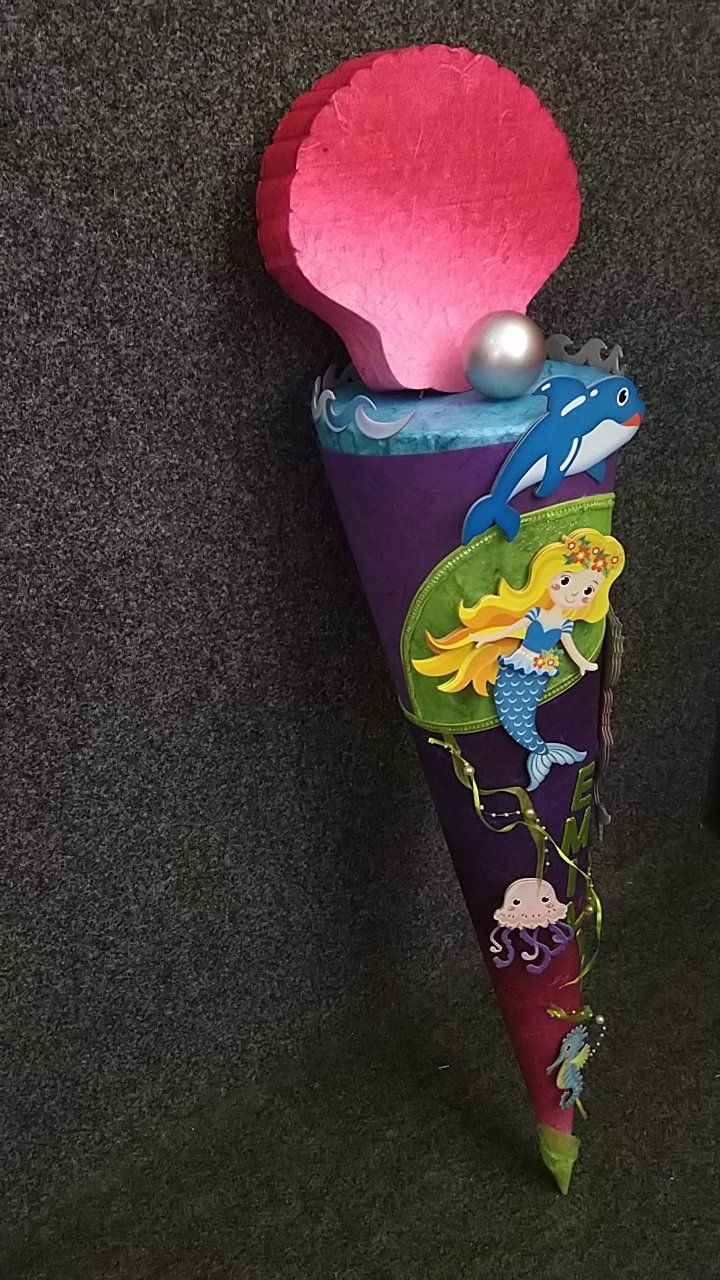 Ein lila Kegel mit einer Meerjungfrau und einem Delphin darauf