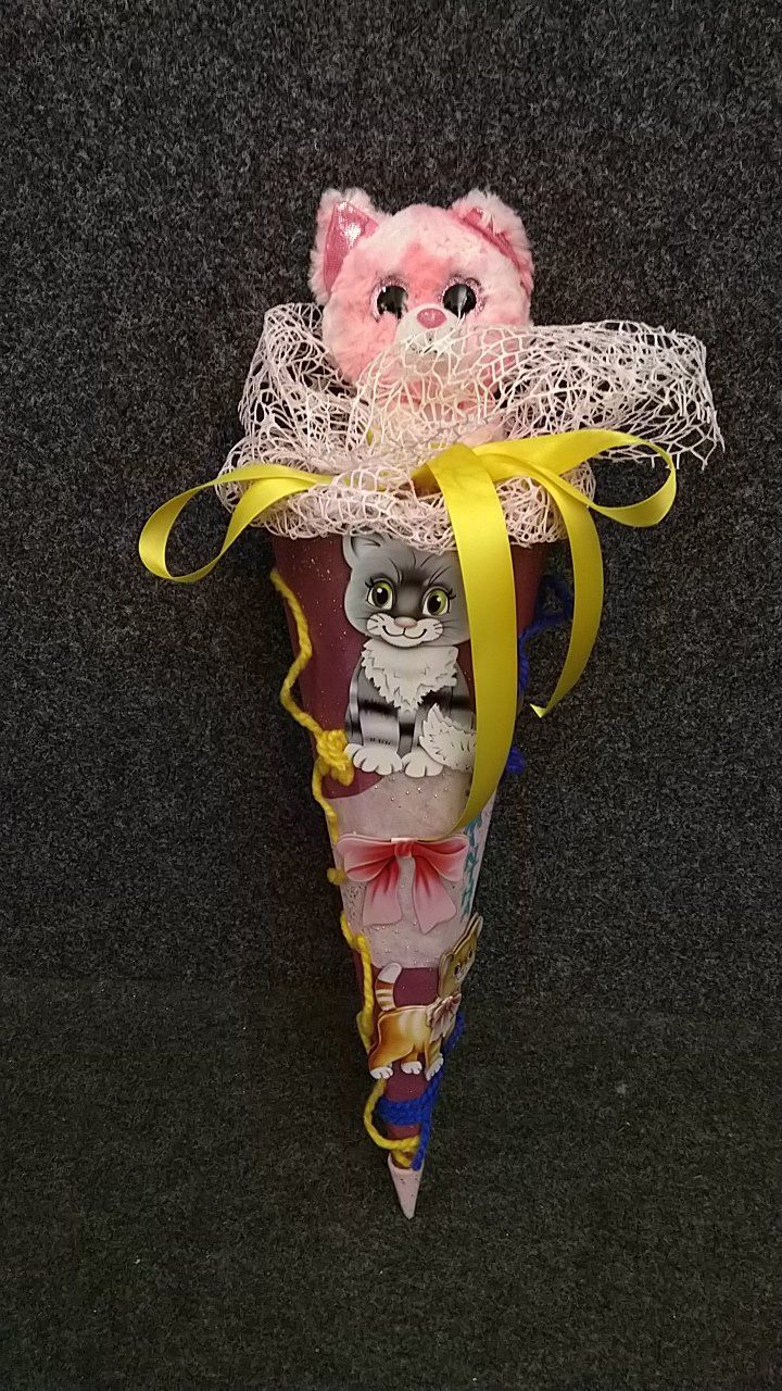 Eine ausgestopfte Katze steckt in einer Tüte mit einer gelben Schleife.