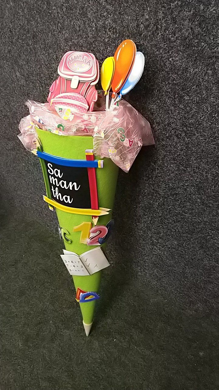 Eine grüne Tüte gefüllt mit Süßigkeiten und Luftballons.