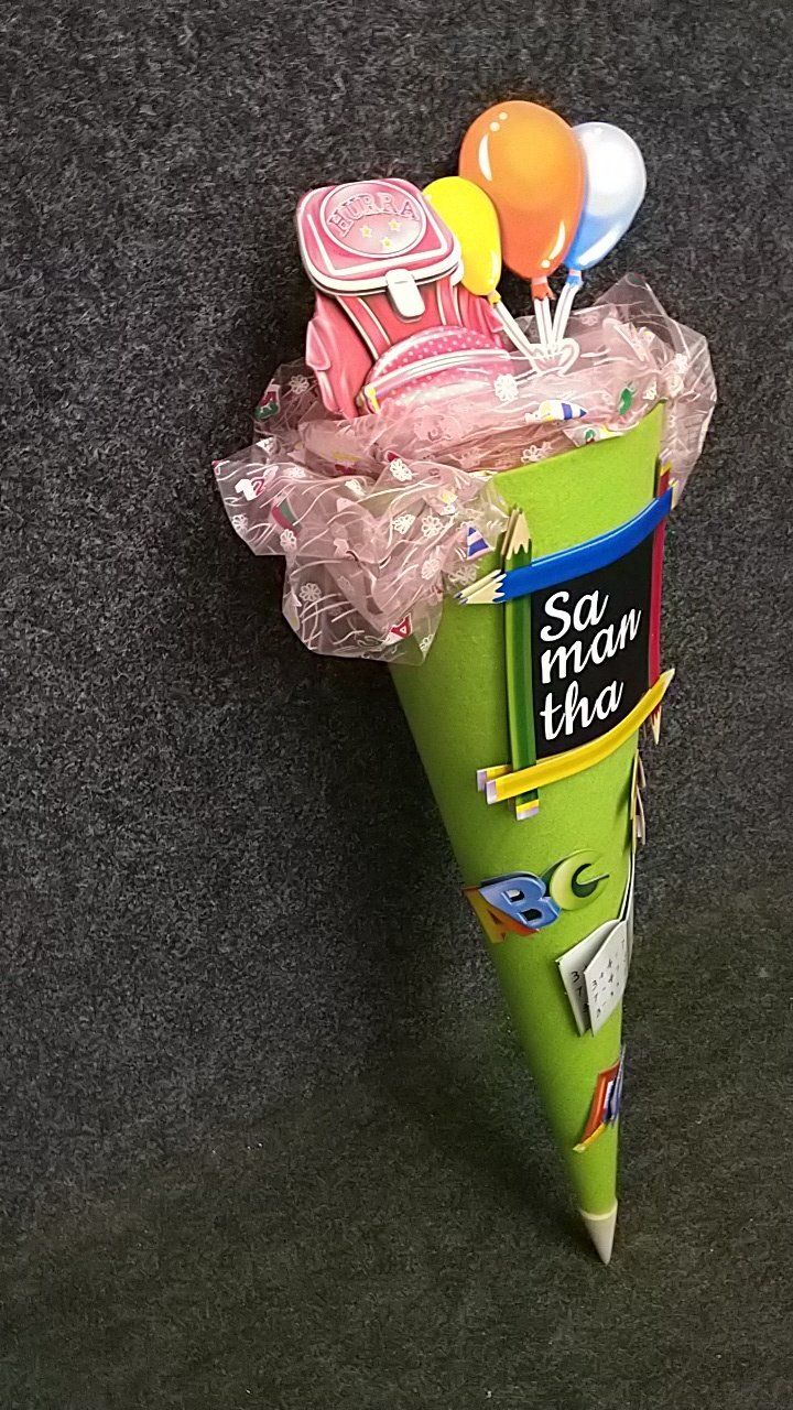 Eine grüne Tüte mit Luftballons und Süßigkeiten darauf