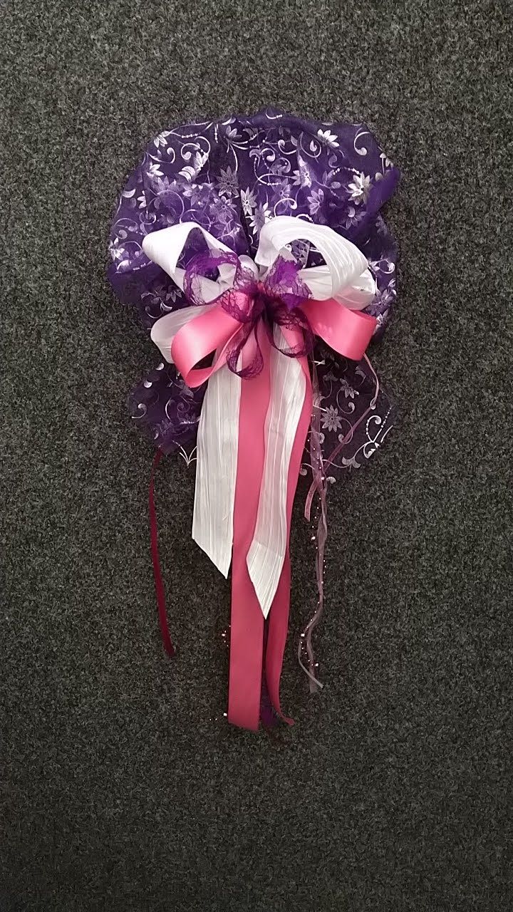 Auf einem Teppich liegt eine lila-rosa Schleife mit einer rosa Schleife.